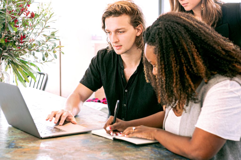 man working on laptop while woman takes notes 3153199