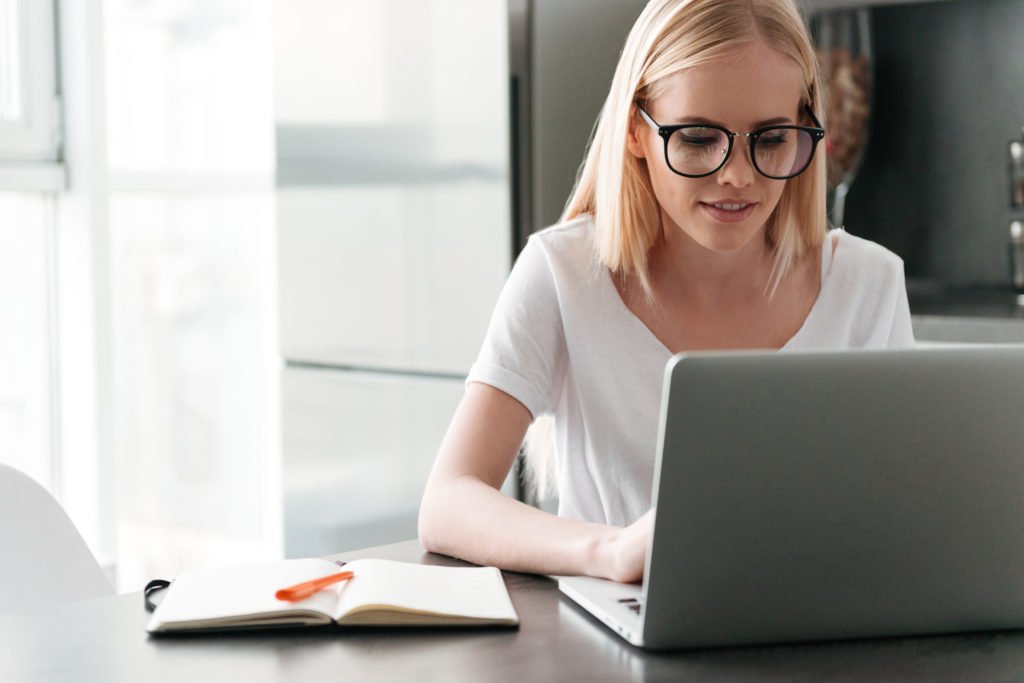 concentrated young lady working with laptop at home