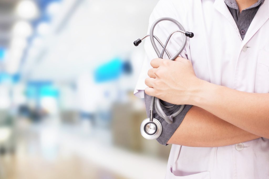 doctor with stethoscope in the hands and hospital background