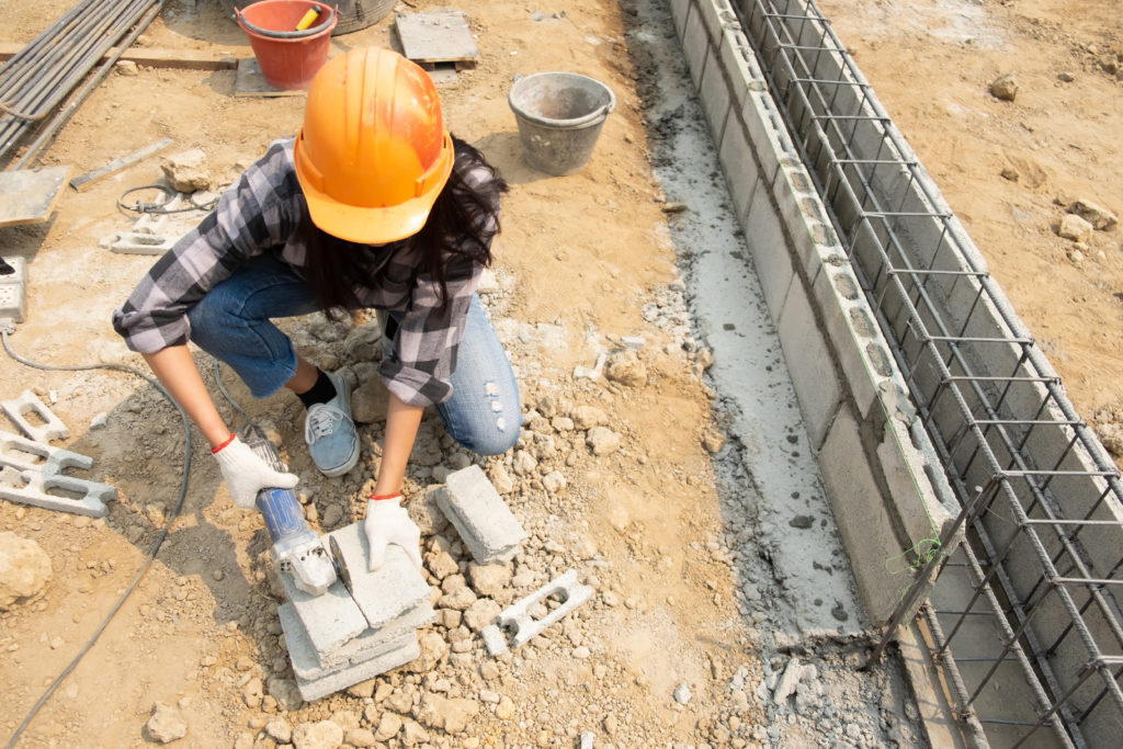 round saw in the hands of the builder work on laying paving slabs