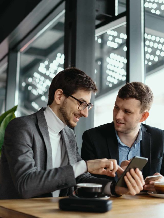 cropped two businessmen having a conversation using a smartphone scaled 1