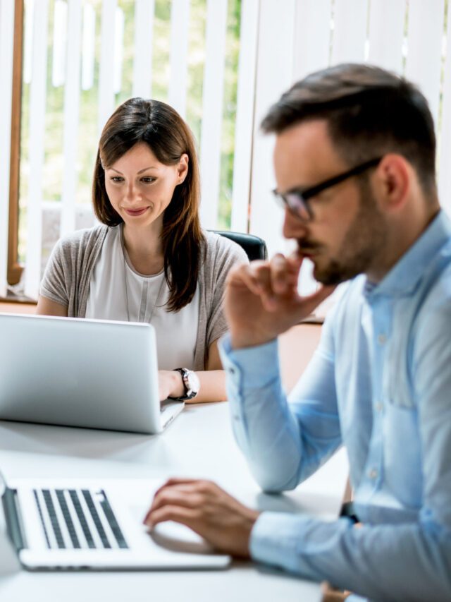 Man and woman are sitting together at the table in the office an