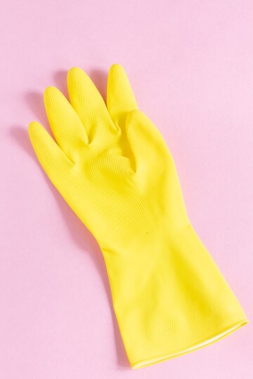 close vertical de uma luva de plastico amarela em uma superficie rosa 181624 41742