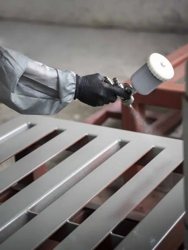 worker-spraying-powder-paint-from-gun-side-view