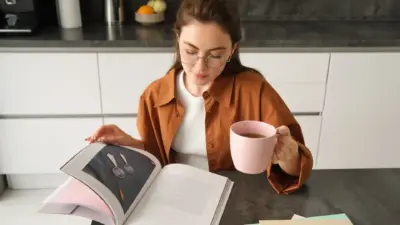 mulher lendo livro na cozinha tomando cha ou cafe