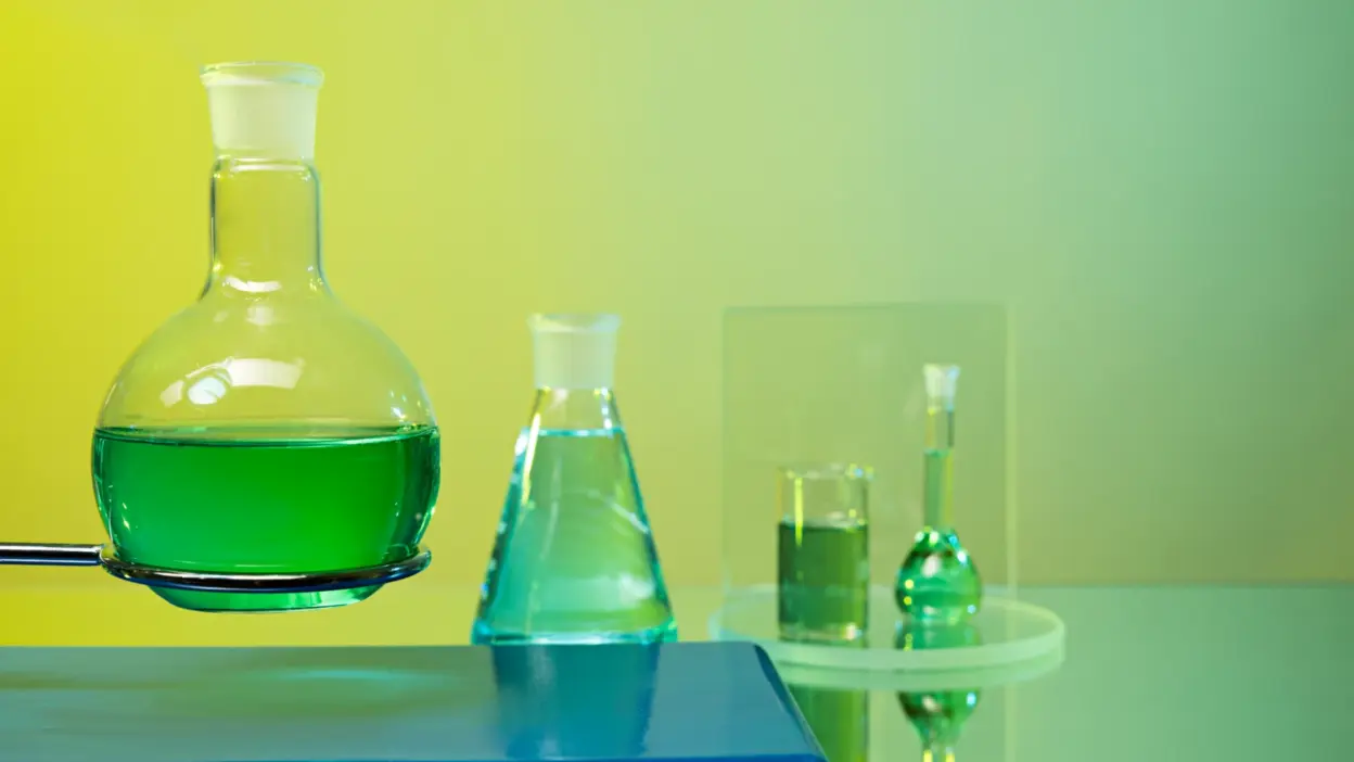 frascos de quimica com liquidos verdes em laboratorio