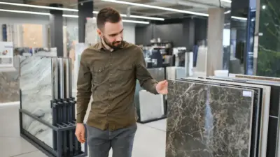 homem analisando pisos de marmore e granito