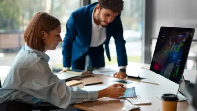 profissionais analisando graficos e dados no computador em reuniao
