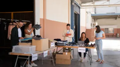 voluntarios organizando doacoes galpao caixas roupas