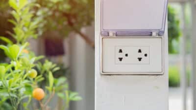 white plug white wall with garden background plug socket electric plug outlet