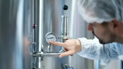 tecnico ajustando manometro equipamento industrial inox