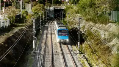 trem azul em trilhos eletrificados vegetacao sinalizacao