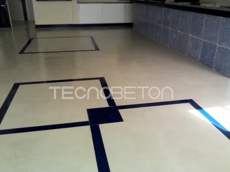 Piso de cimento queimado: como é feito e o que pedir 2 Piso de cimento queimado claro em área comercial, com faixas decorativas escuras que dividem a superfície em retângulos
