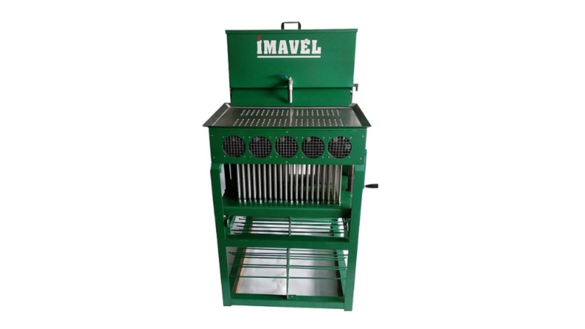 Como montar uma fábrica de velas: espaço, máquina e regras 2 Máquina verde de fabricar velas de maço da Imavel, vista de frente, com fileira de formas e bandejas na parte de baixo