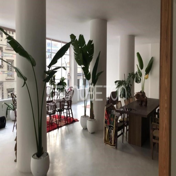 Piso sobre piso: quando dá para revestir sem quebrar 2 Sala com piso cinza contínuo em acabamento cimentício, colunas brancas, plantas e mesa de jantar ao fundo